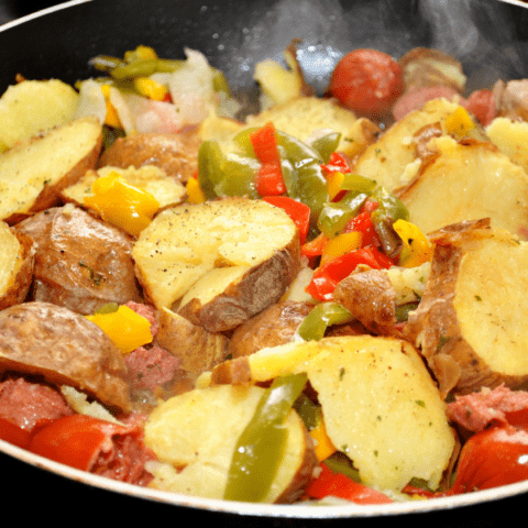 a pan with kielbasa, bell peppers, and potatoes